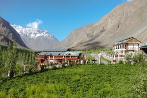a resort in a valley with mountains in the background at The VILLAGE RESORT ASHUNA in Kargil