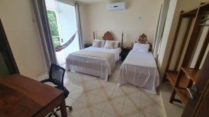 ein Hotelzimmer mit zwei Betten und einem Fenster in der Unterkunft Casa da Barbie na praia de Carapibus PB in Conde + 55 Fotos