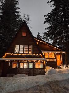 a house with christmas lights on the front of it at Snow Angel Jahorina in Jahorina