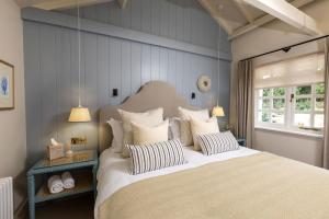 a bedroom with a large bed with striped pillows at The Blue Pigeons Hotel and Restaurant in Worth
