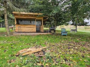 une petite cabane en bois dans un champ avec un arbre dans l'établissement Plume de repos, à Marboué 1 autre photo