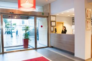 a woman talking on a phone in an office lobby at Hotel Sercotel Portales in Logroño