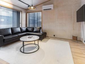 a living room with a black couch and a table at Holiday Home Villa plywood by Interhome in Syöte +11 photos