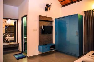a living room with a large blue door and a tv at La Vista Resorts in Wayanad