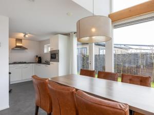 レネッセにあるVilla Duinzicht Renesse by Interhomeの木製のテーブルと椅子のあるキッチンとダイニングルーム +23枚の写真