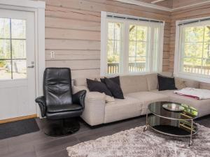 ein Wohnzimmer mit einer Couch und einem Sessel in der Unterkunft Holiday Home Kiehtäjän kuohu by Interhome in Käylä