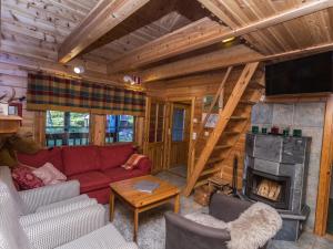 un salon avec un canapé rouge et une cheminée dans l'établissement Holiday Home Marjarinne 8 a by Interhome, à Levi