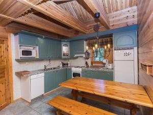 une cuisine avec des placards verts et une table en bois dans l'établissement Holiday Home Marjarinne 8 a by Interhome, à Levi