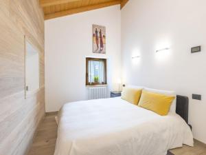 a bedroom with a large white bed with yellow pillows at Holiday Home Borgonuovo Waterfall's House by Interhome in Piuro