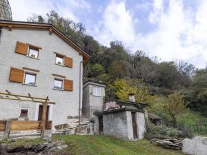 a white house with a wooden roof at Holiday Home Borgonuovo Waterfall's House by Interhome in Piuro