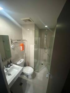 a bathroom with a shower and a toilet and a sink at 101 Newport Boulevard Condo in Manila