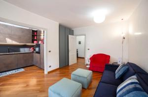 ein Wohnzimmer mit einer Couch und einem roten Sessel in der Unterkunft Venetian Dreams - Giudecca in Venedig