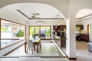 a kitchen and dining room with a table and chairs at Surin villa by Pattara in Ban Lum Fuang