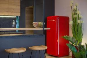 a kitchen with a red refrigerator and two stools at Lux Red - Bukowa Góra in Wisła