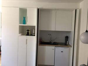 a kitchen with white cabinets and a counter top at L'Elégante in Fécamp +7 photos