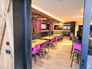 Una fila de mesas y sillas en un restaurante con sillas rosas. en Chalet das rocking home by Interhome, en Aschau