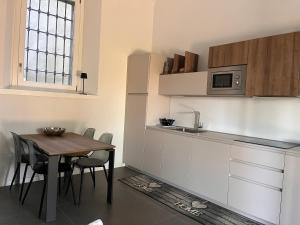 a kitchen with a table and chairs and a microwave at Villa Santa Chiara Lesa - appartamento vista lago con piscina in Lesa