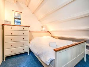 a small attic bedroom with a bed and a dresser at Holiday Home Buitenplaats Schouwen nr 86 by Interhome in Burgh Haamstede