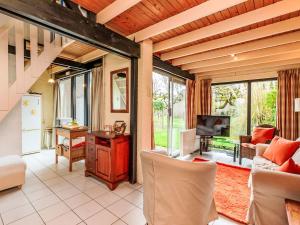 a living room with a couch and a television at Holiday Home Buitenplaats Schouwen nr 86 by Interhome in Burgh Haamstede