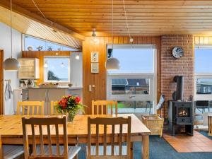 a kitchen and dining room with a wooden table and chairs at Holiday Home Slava - 75m from the sea by Interhome in Hesselager