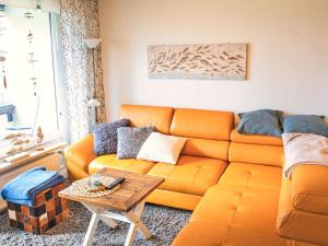 an orange couch in a living room with a table at Apartment Ostsee-Residenz by Interhome in Damp