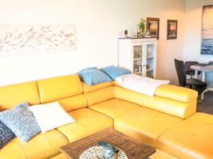 a yellow couch in a living room with a table at Apartment Ostsee-Residenz by Interhome in Damp +17 photos