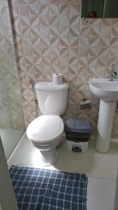 a bathroom with a toilet and a sink at J&m hospedagem in Marau +8 photos
