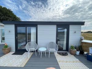 a tiny house with two chairs and a table on a deck at Studio room with amazing views in Abersoch