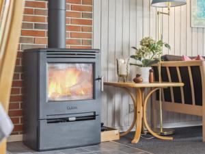 a fireplace with a television next to a table at Holiday Home Blomma - 300m from the sea by Interhome in Humble