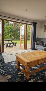 a living room with a wooden table and a patio at Stanloch Farmhouse - well equipped, games room, EV in Glencaple