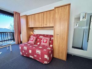 a bedroom with a bed with a cabinet and a balcony at Studio cosy au pied des pistes avec piscine et parking - 4 pers - FR-1-595-19 in Notre-Dame-de-Bellecombe