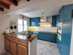 eine Küche mit blauen Schränken und einer Arbeitsplatte in der Unterkunft Holiday Home Charme de la Grande Bosse by Interhome in LʼÉpine