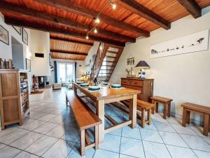 eine Küche mit einem Holztisch und Holzdecken in der Unterkunft Holiday Home Charme de la Grande Bosse by Interhome in LʼÉpine