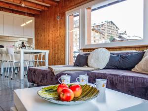ein Wohnzimmer mit einem Tisch und einer Obstschale in der Unterkunft Apartment Bietschorn 20 by Interhome in Nendaz