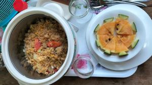 a pot of rice and a bowl of fruit at Bunnum Homestay in Ban Mae Tap