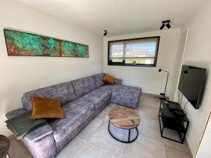ein Wohnzimmer mit Sofa und Tisch in der Unterkunft Holiday Home Seascape Wellness Nieuwvliet-Bad by Interhome in Nieuwvliet-Bad