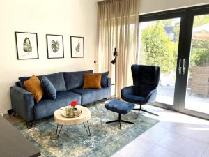 ein Wohnzimmer mit einem blauen Sofa und einem Sessel in der Unterkunft Holiday Home Seascape Wellness Nieuwvliet-Bad by Interhome in Nieuwvliet-Bad