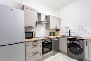 a kitchen with white cabinets and a washer and dryer at The Annick Suite No1 - Donnini Apartments in Irvine +14 photos