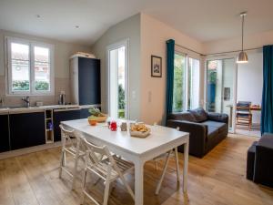 a kitchen and living room with a white table and chairs at Holiday Home Ker Mylio by Interhome in La Bernerie-en-Retz +17 photos