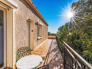 a balcony with a table and chairs and the sun at Apartment T3 Gabriello by Interhome in Cala dʼOro