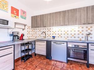 a kitchen with stainless steel appliances and wooden cabinets at Apartment T3 Gabriello by Interhome in Cala dʼOro