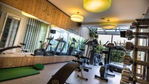 a gym with a bunch of exercise equipment in it at Falkensteiner Hotel & Spa Sonnenparadies in Terento
