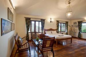 a bedroom with a bed and a table and chairs at Away From Home - 2 - Home Stay Ooty, Entire 4BHK Villa in Ooty