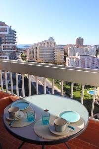 una mesa con platos y tazas en el balcón en Praia da Rocha Tarik, en Portimão
