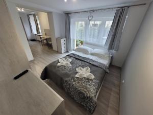 a bedroom with a bed with two flowers on it at 4 Pory Roku in Karpacz