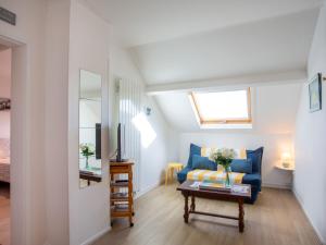 Una sala de estar con un sofá azul y una mesa. en Apartment Les Tilleuls-1 by Interhome, en La Bernerie-en-Retz