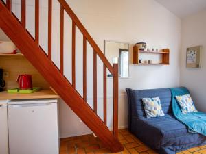 a living room with a blue couch and a staircase at Holiday Home Plein Océan-4 by Interhome in Pornic