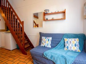 a blue couch in a living room with a staircase at Holiday Home Plein Océan-4 by Interhome in Pornic