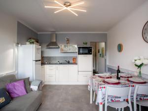 Una cocina y una sala de estar con una mesa y un sofá. en Apartment Les Tilleuls-2 by Interhome, en La Bernerie-en-Retz