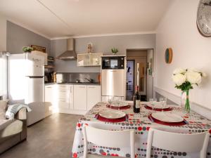 Una cocina con una mesa con sillas y un refrigerador. en Apartment Les Tilleuls-2 by Interhome, en La Bernerie-en-Retz
